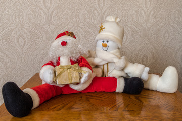 Father Christmas with his friend the Snowman both sitting on table,