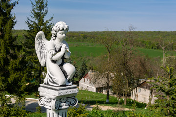Beautiful old stone statue of praying little Angel