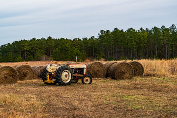 Obraz premium bales of hay and tractor in a field