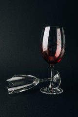 Broken glass by wine glass with blood isolated on black