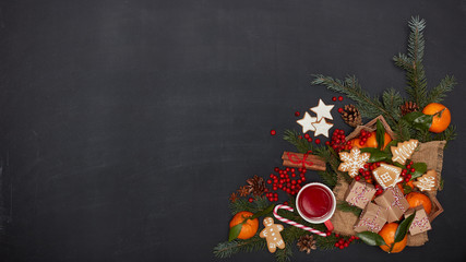 Festive background from fir branches, gift boxes, fruit tea, berries, mandarins with leaves, spices. Christmas. New Year