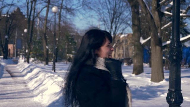Very Happy Beautiful Girl Jumps Hands Up Feeling Awesome Glad Emotion In Snow Covered Park. Winter City Life. Bright Sunny Day. Slow Motion 30 fps 0.5 of real time speed 60 fps