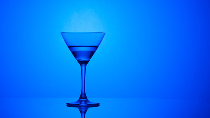 Martini glass on color background