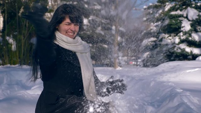 Happy Pretty Girl Throws Snow In Air. Snow Covered Park. Winter City Life. Slow Motion 60 fps 4K	