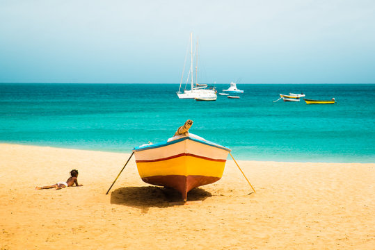 Cabo Verde Islands  Sunny tropical Sal island vacation background of African child silhouette enjoying sandy Santa Maria beach with colourful boats and turquoise water seascape
