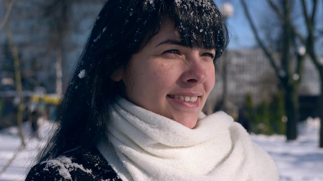Close-up Pretty Female Face. Snowflakes On Hair. Young Adult In Snow Covered City Park On Sunny Day. Slow Motion 30 fps 0.5 normal speed 60 fps