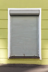 a closed window in a building protected by roller shutters. property and home security
