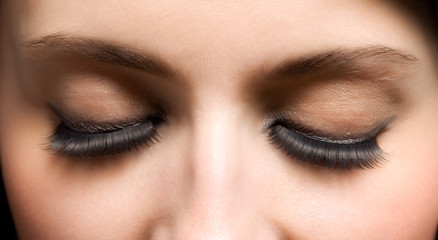 Closed eyes of young womans face with extended lashes