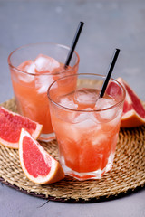 Two Glasses of Tasty Grapefruit Cold Drink or Cocktail Refreshment Beverage Gray Background Cold Grapefruit Juice Vertical