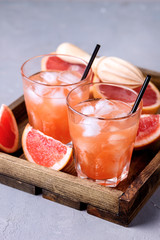 Two Glasses of Tasty Grapefruit Cold Drink or Cocktail on Wooden Tray Refreshment Beverage Gray Background Cold Grapefruit Juice