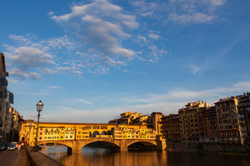 Fototapeta premium The Ponte Vecchio, a medieval stone closed-spandrel segmental arch bridge over the Arno River, in Florence, Italy, noted for still having shops built along it. 
