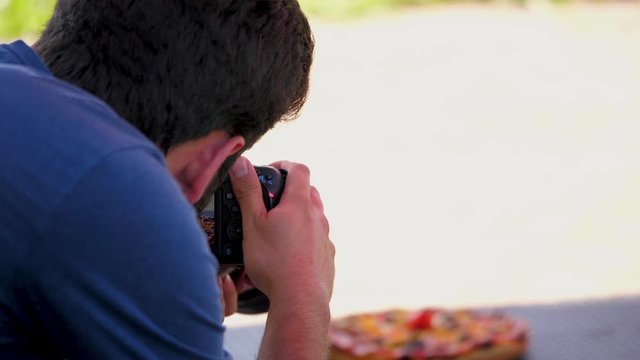 anonymous male photographer taking shot of a pizza close up shot of a man doing food photography