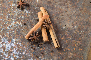 Cinnamon sticks, anise stars and black peppercorns on textured background