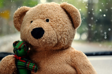 Soft focus, sad and lonely brown teddy bear against a drizzling background.