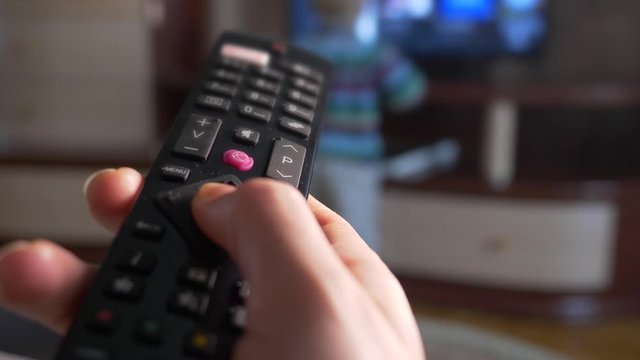 Close-up Macro Female Hand Using Remote Control For Smart TV Set
