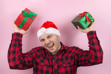 Happy surprised man in a red hat holding a gift with admiration on his face. Positive human...