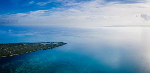 Papier Peint photo Plage de Seven Mile, Grand Cayman aerial drone footage of the island of grand cayman in the cayman islands in the clear blue and green tropical waters of the caribbean sea