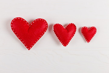 Obraz na płótnie Canvas Red hearts are handmade on white background. Preparation for Valentine's Day with a place for text. Copy space.