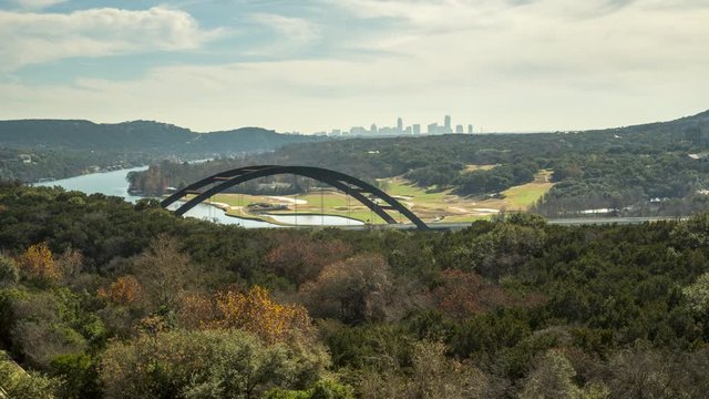 Time Lapse Lawn Mowers in a Golf Course Next to 360 Bridge With Downtown Austin silhouette in the background
