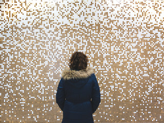 girl standing backwards wearing a parka, with copy space