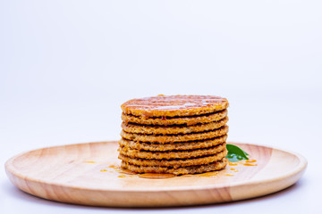 Wafer sprinkled with honey on wooden tray ready to serve.
