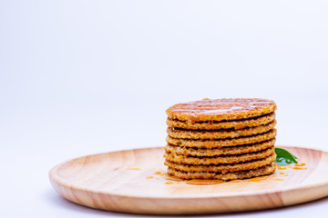 Wafer sprinkled with honey on wooden tray ready to serve.
