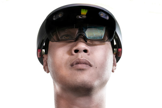 Low view portrait of asian man experiences Mixed reality with HoloLens 1 on white background. Future advanced technology concept