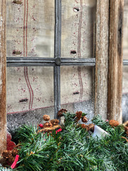 noel decoration with pine tree branches in front of a window