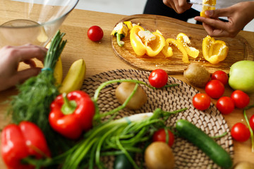 Table flatlay with cutted fresh red and yellow peppers, green onion, cerry tomato and other vegetables and fruits