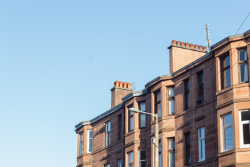 Fototapeta na wymiar Glasgow street photography: brick buildings against the blue sky