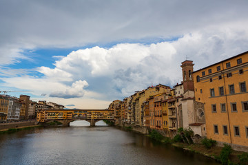 The Ponte Vecchio, a medieval stone closed-spandrel segmental arch bridge over the Arno River, in Florence, Italy, noted for still having shops built along it.  