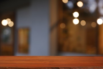 wood table in front of blurred cafe exterior