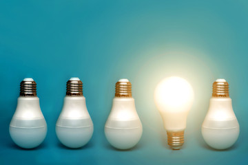 Among others, a bright light bulb shines. conceptual ideas and ideas. stands out among others. a...
