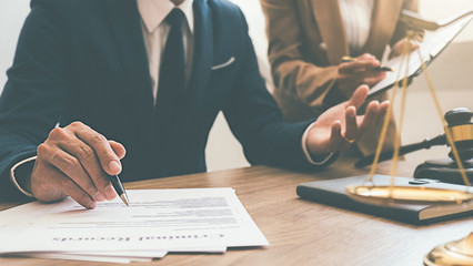 Judge gavel with Justice lawyers having team meeting at law firm background. Concepts of Law and Legal services.