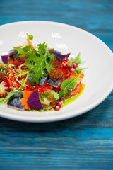 Escabeche fish dish with caviar: mackerel in marinade with vegetable, on a plate on the wooden blue background.