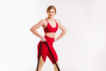 Young fitness woman doing exercises with sport fitness rubber bands on white background