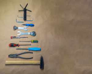 Symbol Christmas tree made of work tools, hammer, pliers, screwdrivers on a paper background, top view.