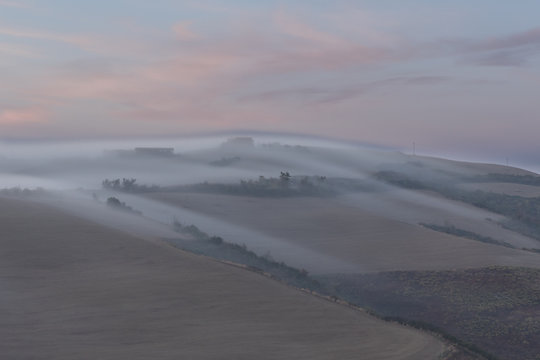 Morning fog rolling over Tuscan hils in Italy