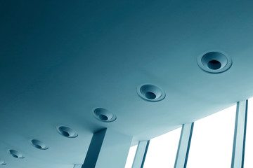 Air ducts on pitched ceiling of industrial or office building. Ventilation or air conditioning system. Modern architecture, industry, technology, engineering and interior design with girder and window