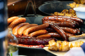 Prague, Czech Republic 2019:Traditional hot dog preparation on coal fire on the street during the Christmas market