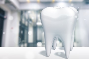 Human's white tooth on hospital background