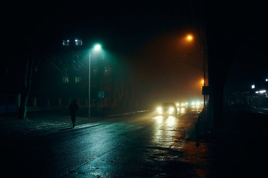 Fototapeta fog in the night city after rain, car headlights