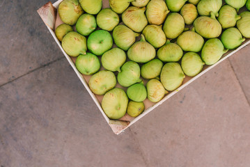 Fresh ripe figs in wooden box on the market, lifestyle view.