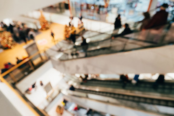 Abstract blurred background of the shopping center. Unfocused escalators with people