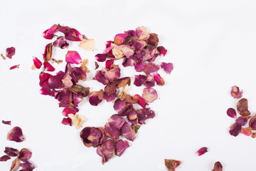 heart of new and dried rose petals on white background