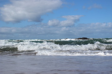 Waves at the beach with cloudy sky