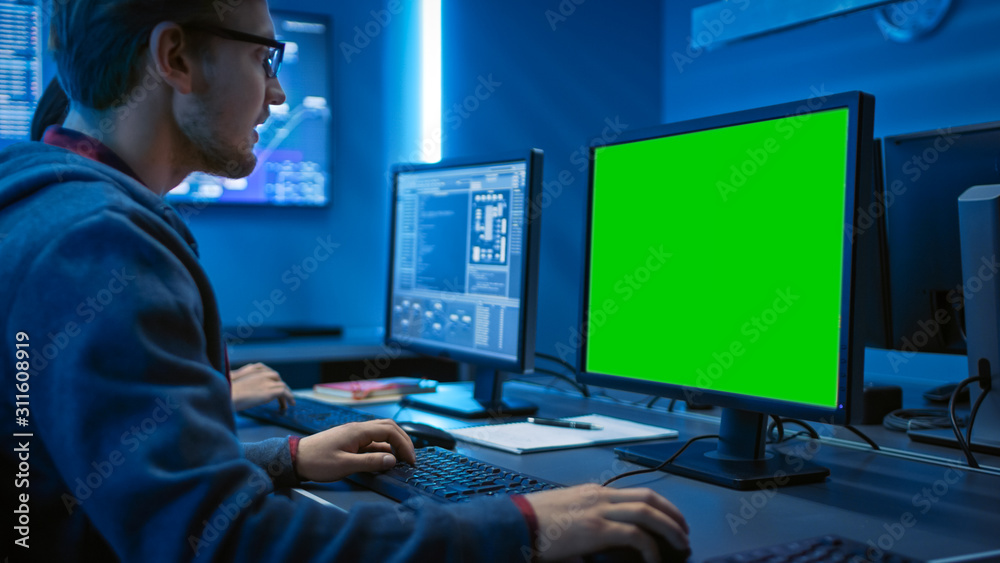 Poster Smart Male IT Programer Working on Desktop Green Mock-up Screen Computer. Software Development / Code Writing / Website Design / Database Architecture. Technical Department Office