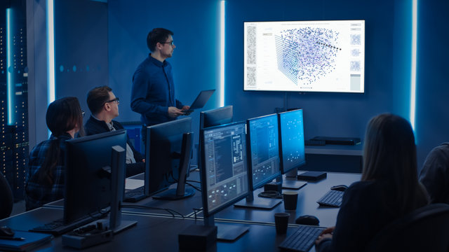 Team of Professional IT Developers Have a Meeting, Speaker Talks about New Blockchain Based Software Development Shown on TV. Concept: Software Development, Deep Learning, Artificial Intelligence