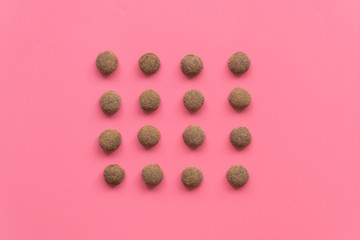 pattern of dry food for cats or dogs on pink background