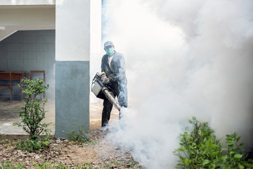Man work fogging to eliminate mosquito for preventing spread dengue fever